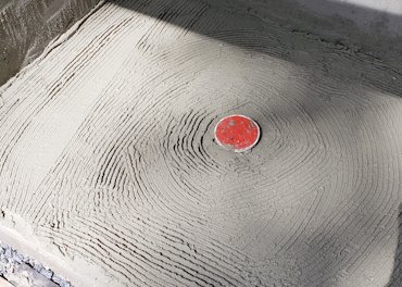 Scratch coat on the concrete slab has a lot of acrylic bonder.